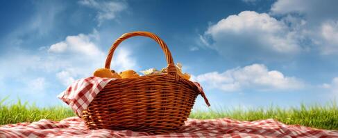 The wicker basket filled with picnic delights under a bright blue sky. photo