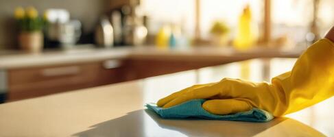 The hand cleaning a countertop with a colorful cloth in a sunlit kitchen. photo