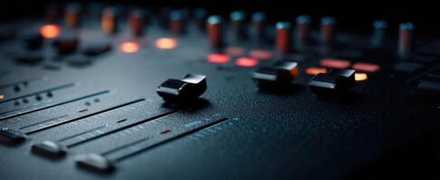 The audio mixing console with sliders and glowing buttons in a dark studio setting. photo