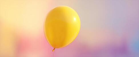 The bright yellow balloon floating against a soft colorful background. photo
