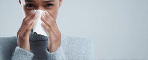The woman in a gray sweater holding a tissue, expressing distress and discomfort. photo