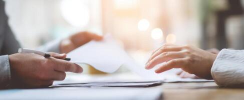 The engaged hands exchanging important documents in a business meeting. photo