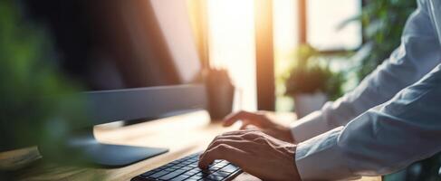 The hands of a professional typing on a computer keyboard in a bright workspace. photo