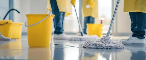 The team of cleaners efficiently mopping the floor with yellow equipment. photo