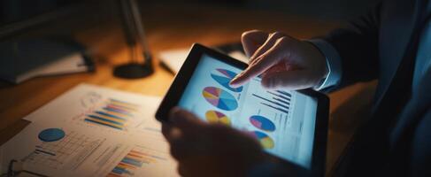 The tablet displaying colorful charts and graphs in a professional workspace. photo