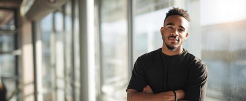 The young man confidently poses by large windows in modern interior. photo