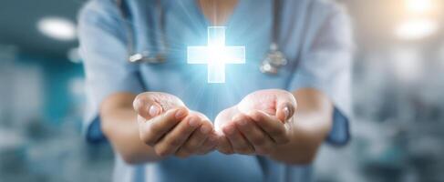 The doctor presenting a glowing medical cross above hands in healthcare setting. photo
