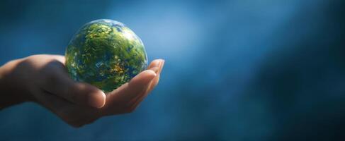 The hand holds a miniature globe symbolizing global unity and environmental care. photo