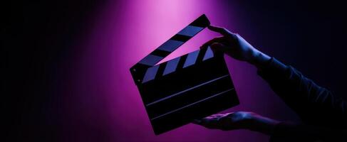 The clapperboard illuminated in a dramatic purple lighting setup. photo