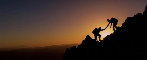 The climbers reaching new heights together against a breathtaking sunset background photo