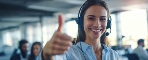 The cheerful woman in headset giving a thumbs up in modern office environment. photo