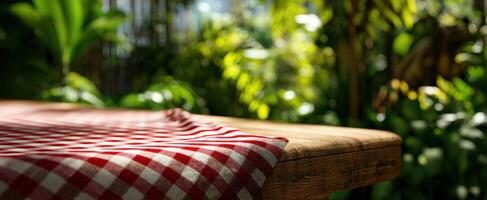 The rustic table adorned with checkered cloth amidst lush greenery and sunlight. photo