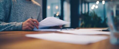 The focused individual analyzing paperwork at a modern office workspace. photo