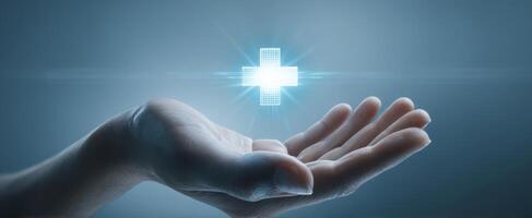 The hand offering a glowing medical cross symbol for health care services. photo