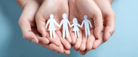 The hands holding paper figures representing family and unity in a supportive environment. photo