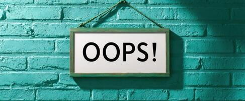 The playful Oops sign hanging against a vibrant turquoise wall. photo