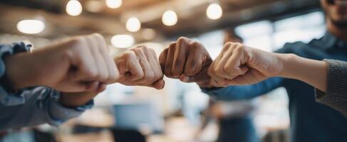 The teamwork gesture of fist bumps among diverse professionals in an office setting. photo