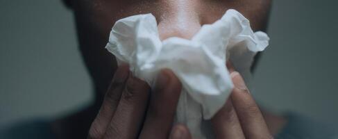 The person holding a tissue in their hands, expressing discomfort and concern. photo