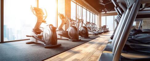 The modern gym with elliptical machines and a bright urban view. photo