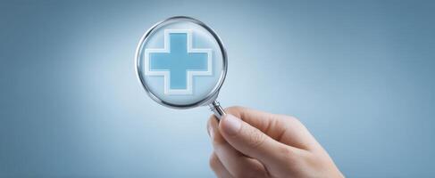 The hand holding a magnifying glass revealing a medical cross symbol. photo