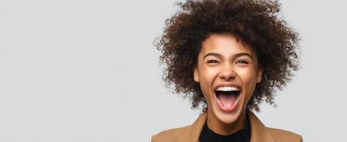 The joyful woman with curly hair expressing happiness and excitement in a studio setting. photo