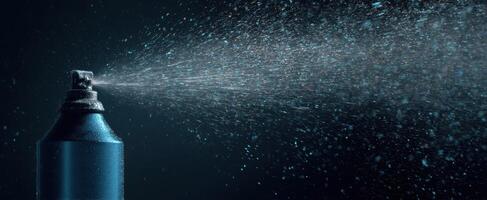 The vibrant blue aerosol can spraying fine mist in dark background photo