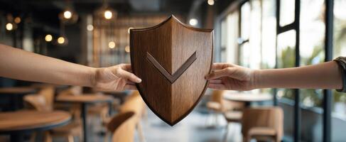 Two people holding a wooden shield over a table photo