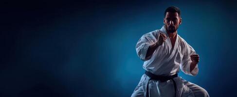 The karate fighter showcasing strength and focus in a dramatic pose. photo