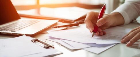 The professional hand writing notes on documents at a modern office desk photo