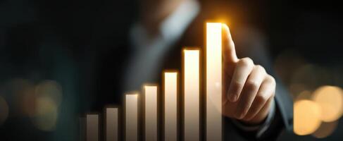 The businessman touching a glowing growth chart indicating success and progress. photo