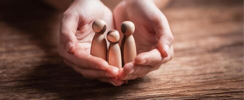 The wooden figures representing family unity and support in caring hands. photo