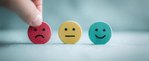 The hand selecting between emotional expression tokens for feedback. photo