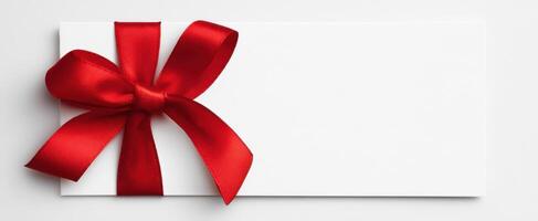 The elegant gift card with a striking red ribbon and bow delicately arranged. photo