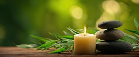 The tranquil arrangement of stones and a candle next to green leaves photo