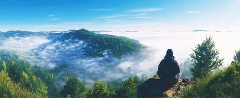 The serene view of a person meditating on a foggy mountain top photo