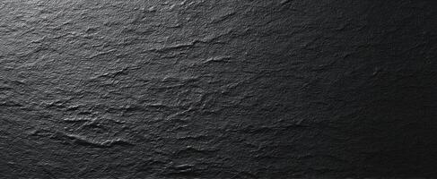 The textured black slate surface with elegant natural patterns and variation. photo