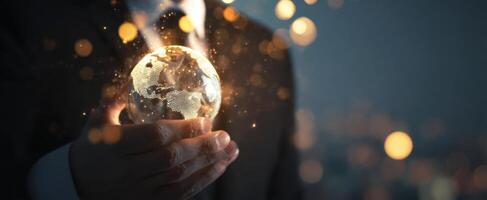 The businessman holding a glowing globe symbolizing innovation and global connectivity. photo