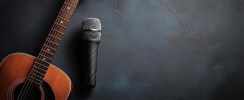 The acoustic guitar and microphone set against a dark background for music events. photo