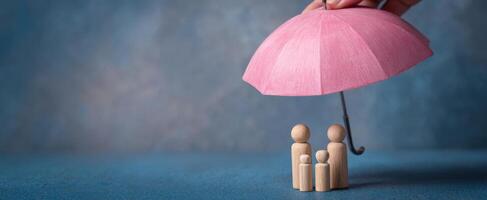 The family under a protective pink umbrella symbolizing safety and togetherness. photo