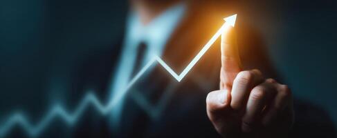 The hand pointing towards an upward growth trend in business metrics. photo