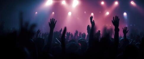 The crowd celebrating at a vibrant live concert with raised hands. photo