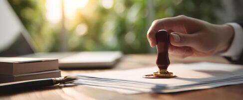 The elegant hand applying a seal on important documents in a modern office. photo