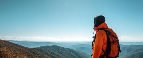 The adventurous hiker overlooking stunning mountain vistas under a clear blue sky. photo