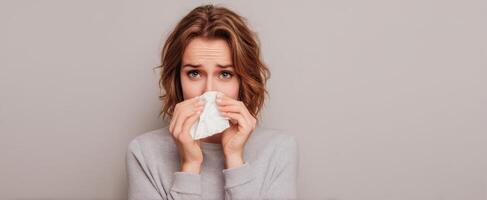 The woman struggling with allergies while holding a tissue in her hands. photo