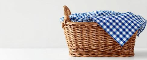 The wicker basket with blue checkered cloth ready for a picnic or storage. photo