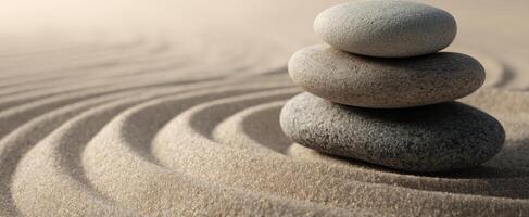 The serene balance of stones resting on smooth, flowing sand. photo