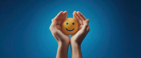 The hands holding a cheerful smiley face against a vibrant blue background. photo