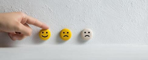 The hand pointing at three emoticon faces representing different emotions photo