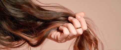 The Hand Grasping Beautiful Long Hair Against a Soft Background photo