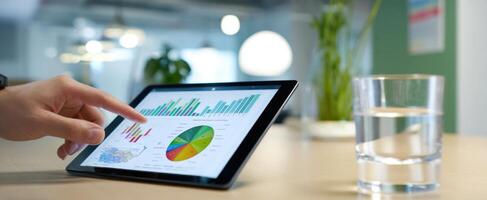 The tablet displaying interactive charts and graphs in a modern business environment. photo